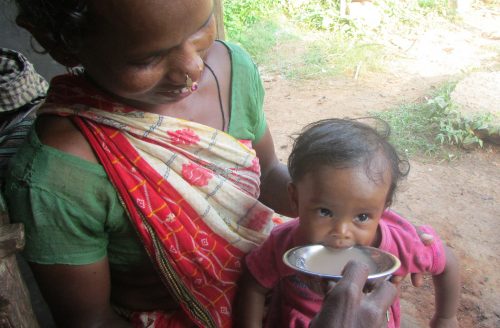 A tribal woman feeding her son nutritious ragi soup.